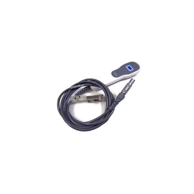 A medical device with a small display, connected by a cord to a clip, rests on a white surface.