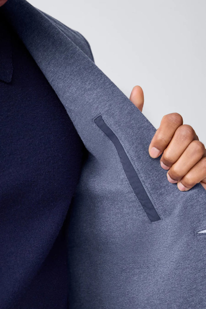 The MACK WELDON Ace Blazer in True Black is a two-button French terry blazer with notched lapels, front patch pockets, and cuff button details, shown against a plain white background.