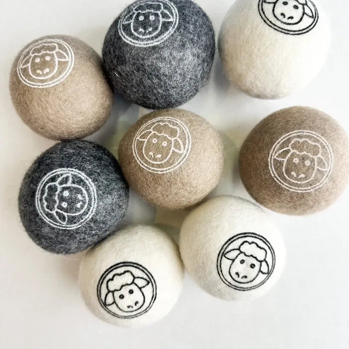 Set of nine wool dryer balls with sheep designs on a white background