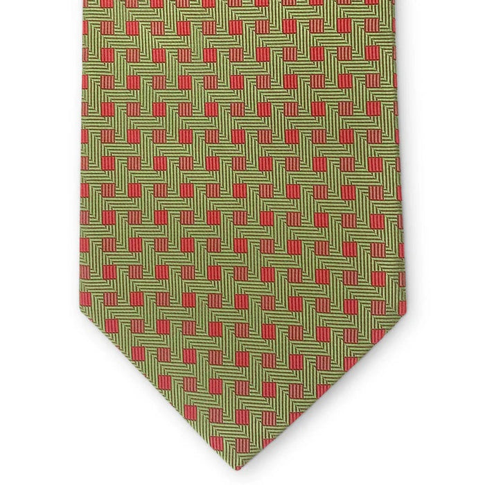 The PETER-BLAIR Bespoke Small Squares Silk Tie in Green by BIRD DOG BAY features a geometric red square pattern and is handmade in New York, shown rolled up on a white surface.