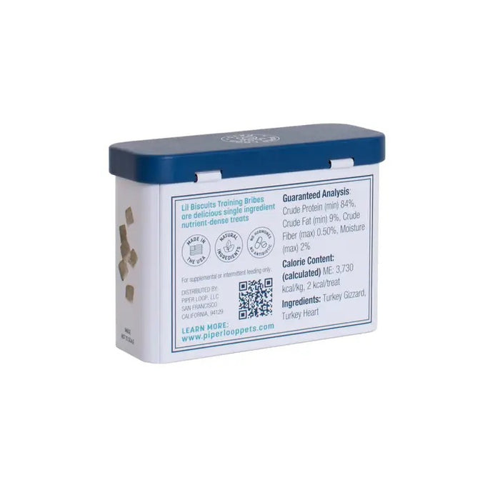 A rectangular tin with a blue lid labeled “PIPER LOOP PETS - LIL BISCUIT TRAINING BRIBES, FREEZE-DRIED TURKEY” features a puppy photo and contains 100% turkey, protein-rich treats for training and emergency recall.