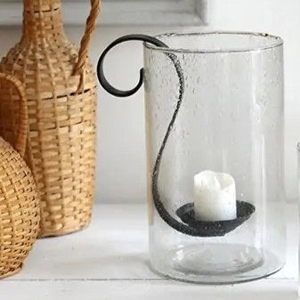 The RECYCLED BUBBLE GLASS HURRICANE WITH METAL VOTIVE HOLDER by CREATIVE COOP features artisanal textured recycled glass and a metal votive holder, beautifully displayed against a crisp white background.