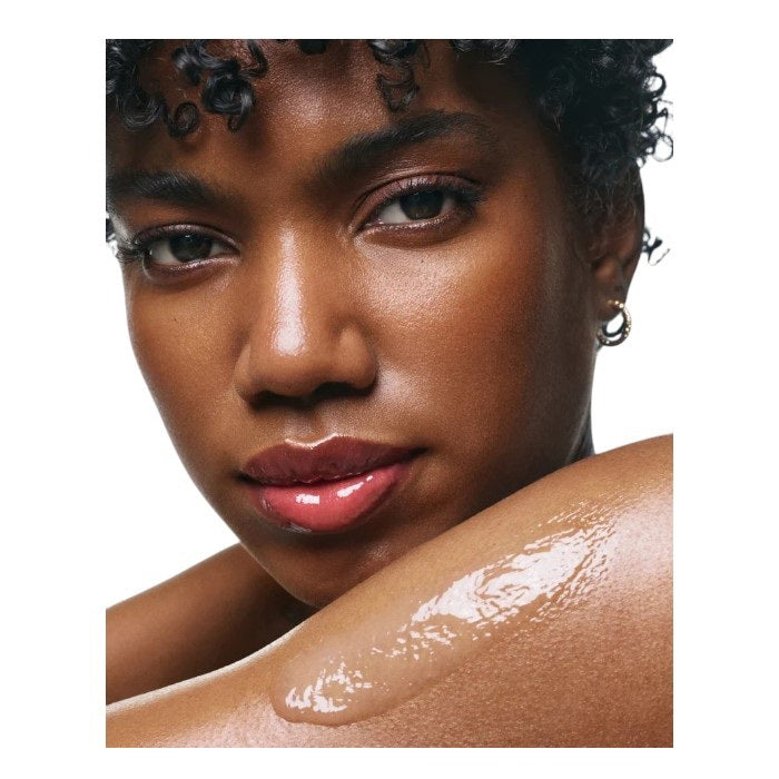 A tall, white bottle with a minimalist design and black text displays "U BEAUTY RESURFACING BODY COMPOUND 200ML." This body exfoliant is formulated to improve skin texture for a smoother look.