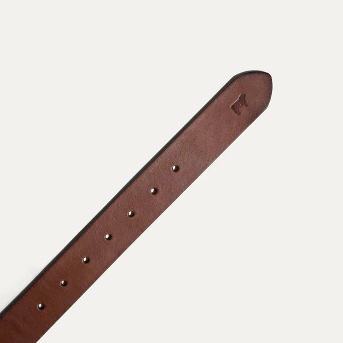 The WILL LEATHER GOODS Saddle Belt in Cognac features full grain vegetable-tanned leather, a classic roller buckle, and a small embossed logo near the tip, shown coiled neatly on a plain white background.