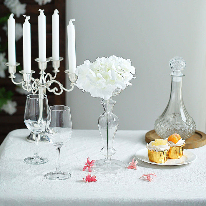 Elegant table setting with floral centerpiece, candles, and dessert treats.