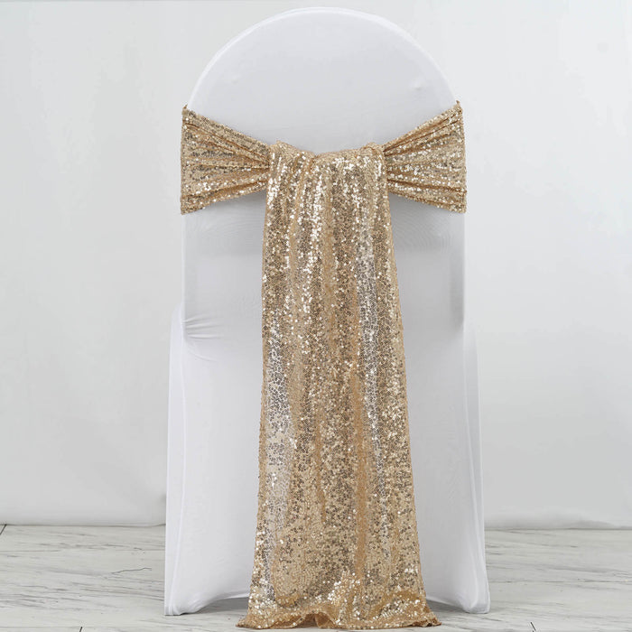 Gold sequin chair cover sash on a white chair against a plain background.