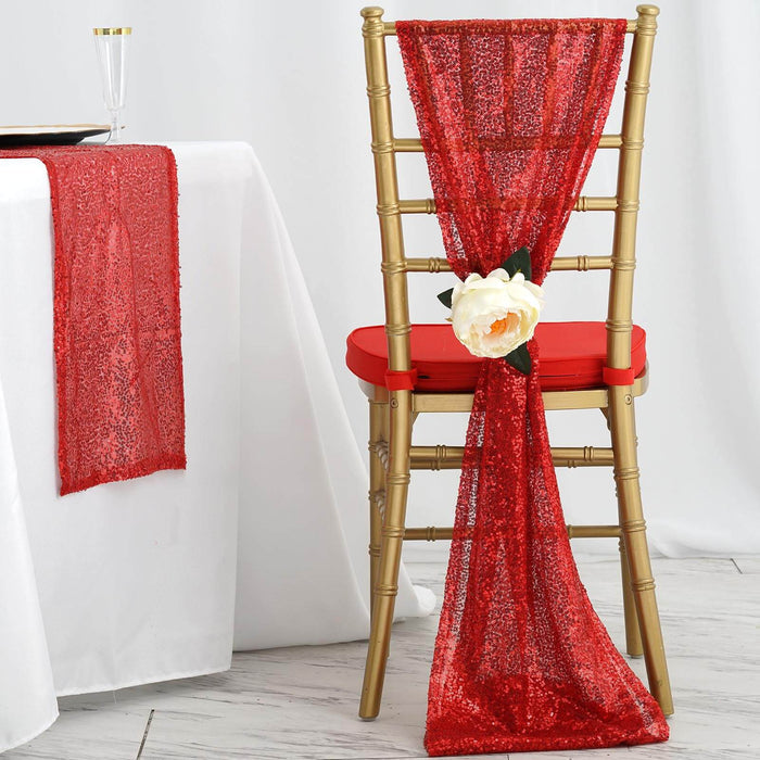 Red sequin chair sash with flower decoration on a gold chair.