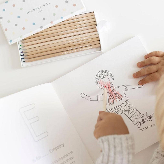 Child using Affirmation Colouring Pencils to color a drawing in a workbook, promoting mindfulness and creativity.