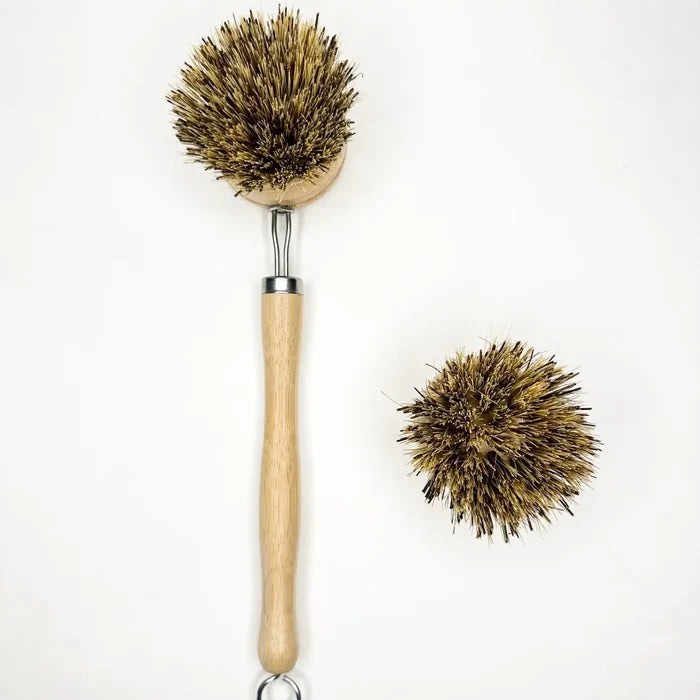 Dish cleaning brush with natural bristles and wooden handle on a white background