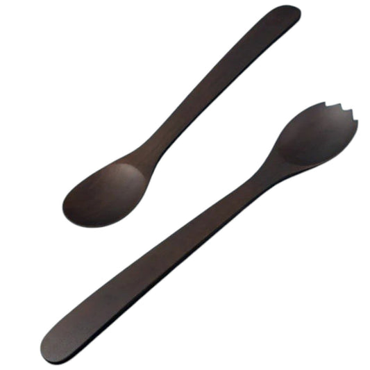 Dark wooden utensils, eggs, herbs, lemon, corn kernels, and spices are arranged neatly on a white textured surface, with the BE HOME - EBONY TEAK STREAMLINED SERVING SET by BE HOME, INC adding a touch of luxury dining. Small dark bowls surround the main items for an elegant yet inviting presentation.