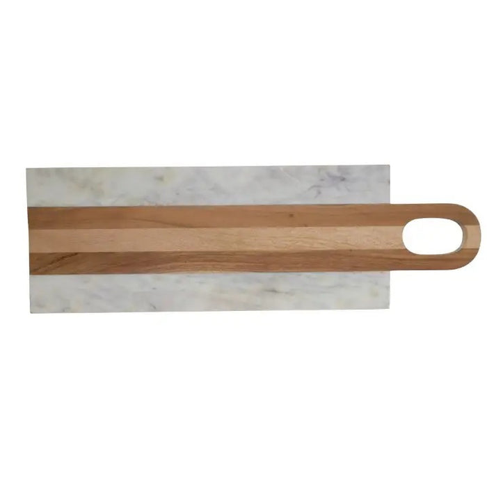 A kitchen scene features four BE HOME - MOA MARBLE & WOOD LONG BOARDS by BE HOME, INC, surrounded by herbs, sliced lemon, cherry tomatoes, olive oil, spice jars, a glass of wine, and bread on a beige countertop against a textured beige wall.
