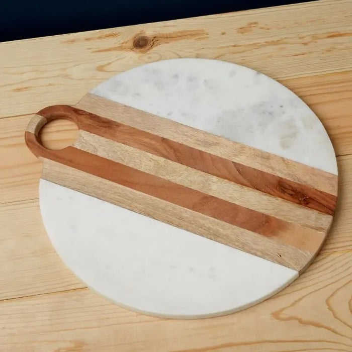 The BE HOME - MOA Marble & Wood Round Board by BE HOME, INC is handmade in India, featuring a central wooden stripe on white marble and finished with a circular top handle.