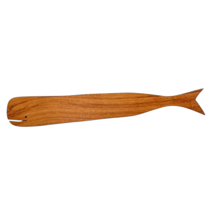 The BE HOME - TEAK WHALE SPREADERS by BE HOME, INC rest on a round white marble cutting board with a hole at the top, displayed on a wooden surface.