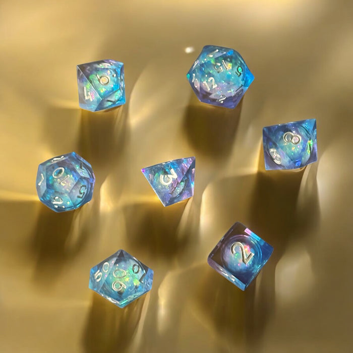 7-piece blue and purple prismatic cosmos dice set with glitter, D&D polyhedral set – Raven's Cauldron, 6 N Sandusky St, Delaware, OH 43015