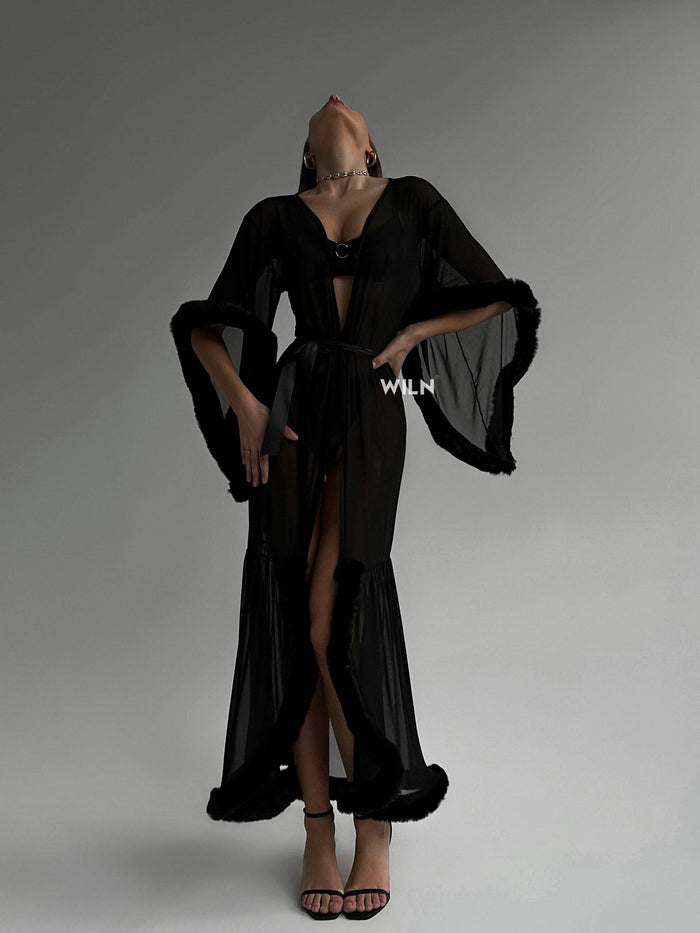 Model wearing BURLESQUE Soft Mesh Dress with dramatic sleeves and a high slit, showcasing elegance and confidence.