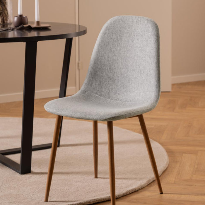 Gray chair in a room with a table and candles