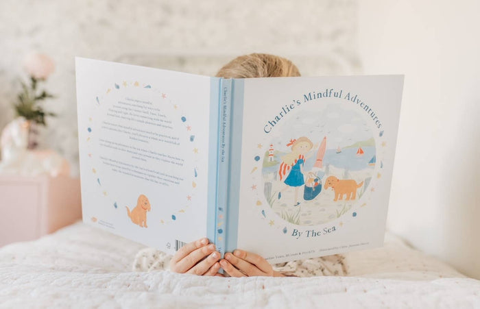 Child reading Charlie's Mindful Adventures By The Sea book, promoting mindfulness and emotional awareness.