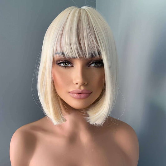 Woman wearing a blonde wig with bangs against a gray background