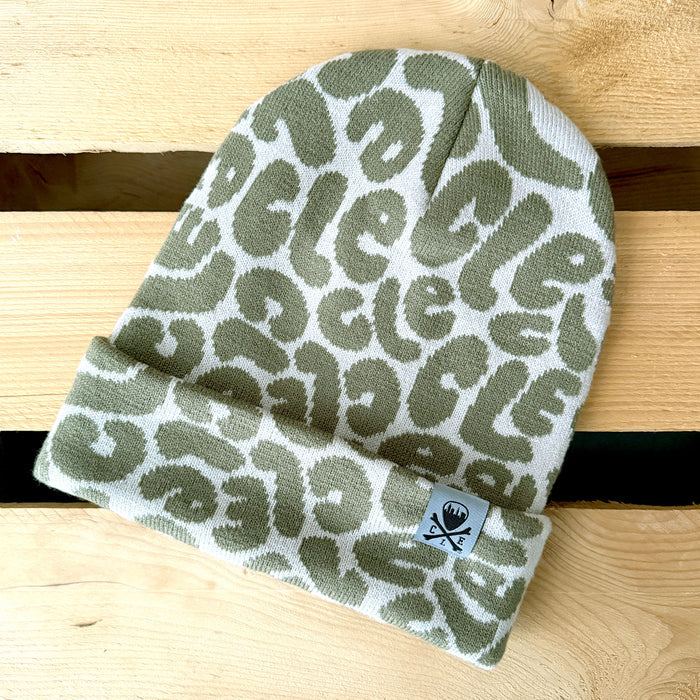 Green patterned beanie on a wooden surface