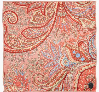 The CLIFTON WILSON - SILK PEACH PAISLEY POCKET SQUARE features a vibrant paisley design in red, orange, blue, and yellow with intricate floral and leaf motifs—a refined formal accessory from CLIFTON WILSON.