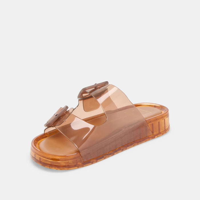 The DOLCE VITA - JULIO WHISKEY SANDAL by DOLCE VITA is a translucent orange jelly sandal with two wide straps, bold matching buckles, and a flat chunky sole for a simple, modern look.