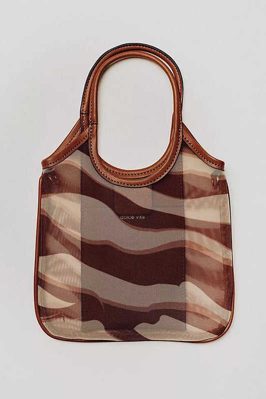 The DOLCE VITA Sylvene Crossbody Mesh Bag in Sebra features brown leather handles and trim, a semi-transparent body with a wavy brown-beige camouflage pattern, and "Dolce Vita" printed on the front.