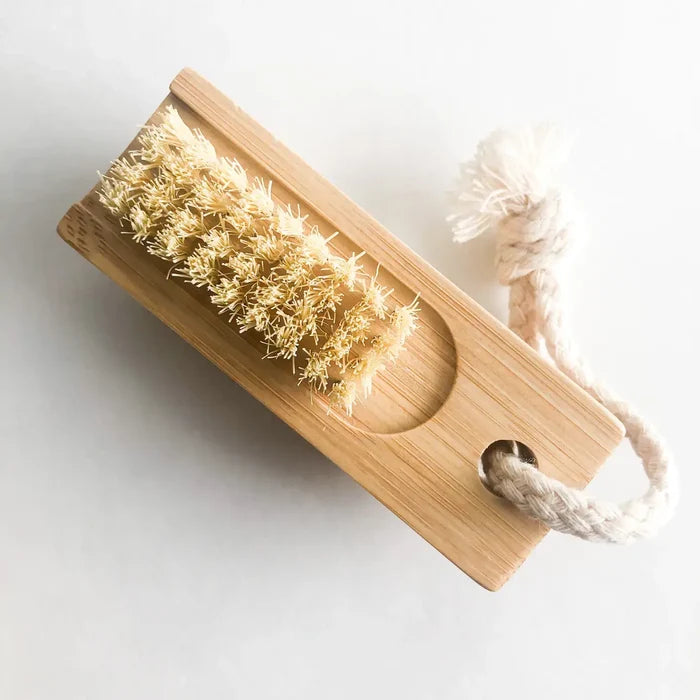 Wooden brush with natural bristles and a rope handle on a light background