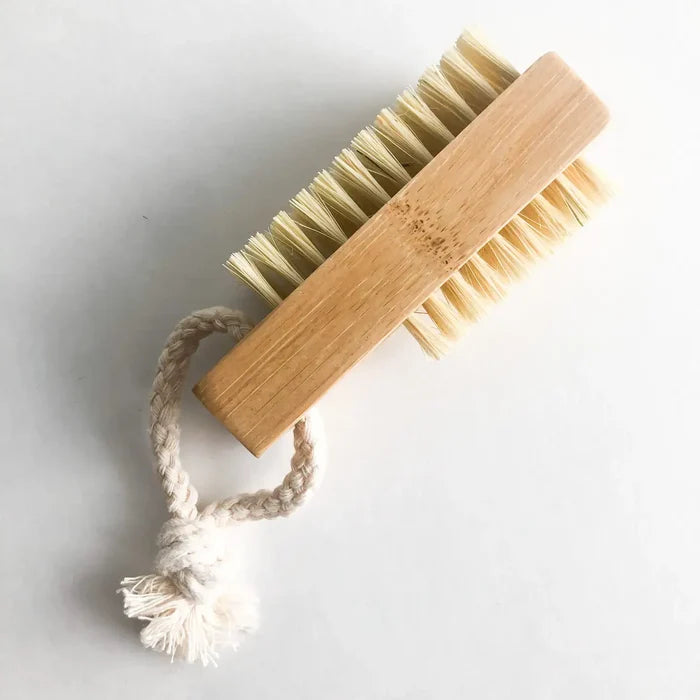 Barefoot brush with wooden handle and natural bristles on a light gray background