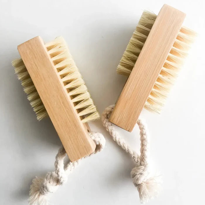 Two wooden brushes with natural bristles on a light background