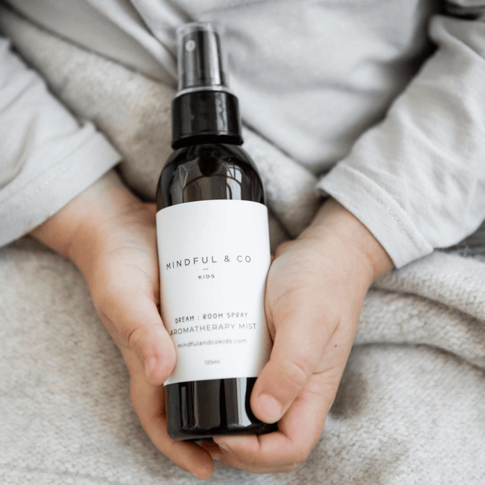 Dream Aromatherapy Spray bottle held in child's hands for restful sleep