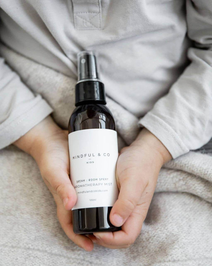 Dream Aromatherapy Spray held by a child, designed to promote restful sleep for kids.