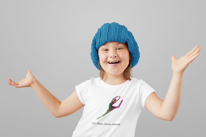 Child wearing a blue knitted hat and white t-shirt with a colorful design on a gray background