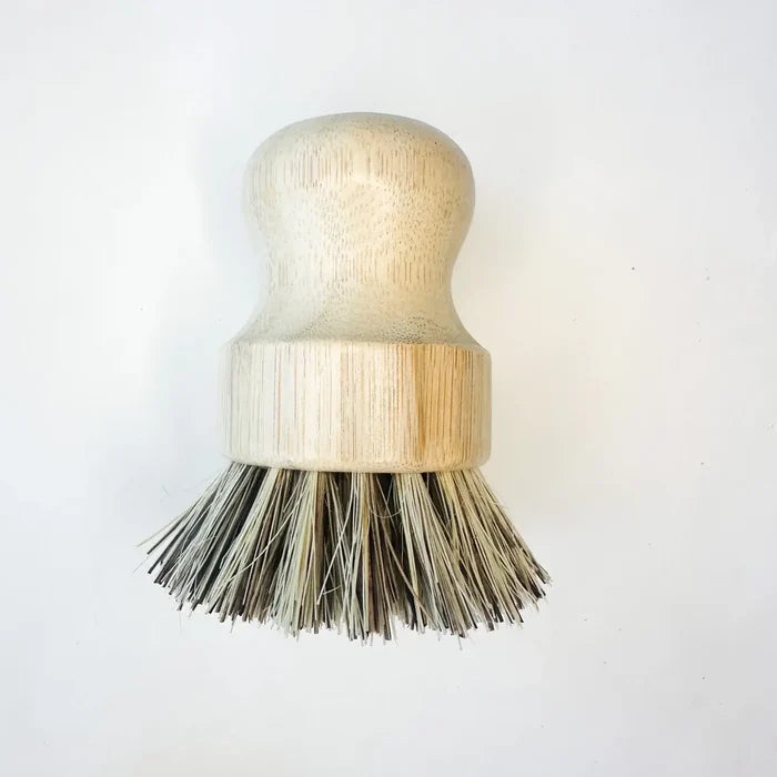 Dishwashing brush with wooden handle and bristles on a white background