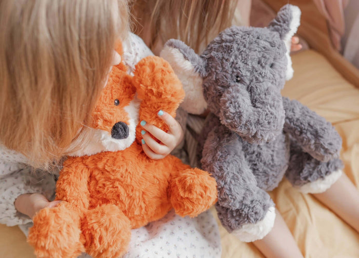 Children cuddling cute orange fox and grey elephant plush toys, perfect for comfort and relaxation for kids.