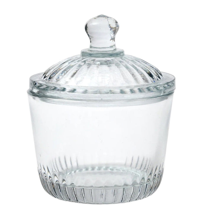 Two ETUHOME Bistro Glass Bon Bon Jars with ribbed lids sit on a wooden surface, one filled with yellow candies and the other nearly empty. Wrapped sweets are scattered nearby, creating a charming ETUHOME display.