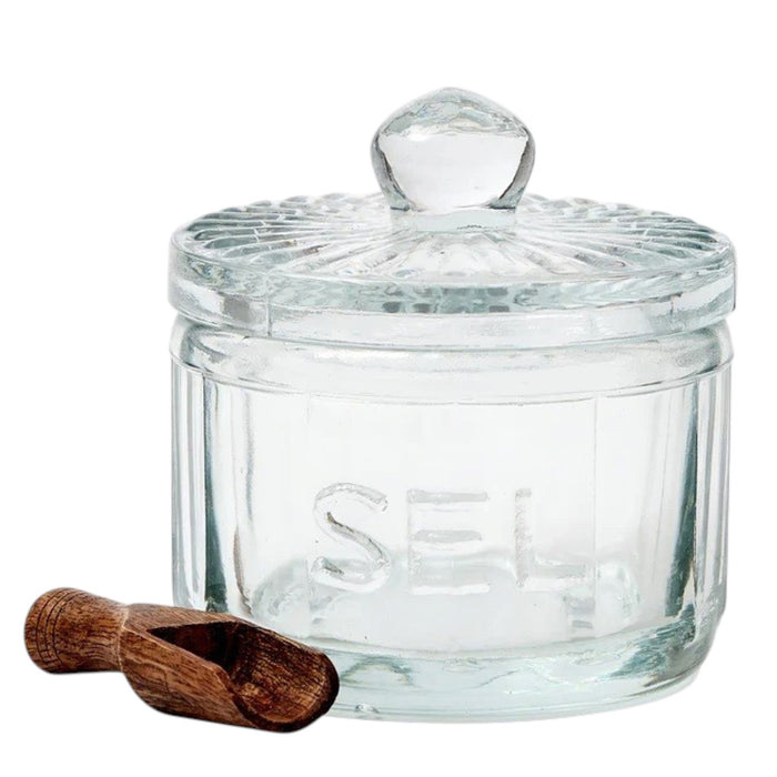 The ETUHOME Bistro Glass Salt Cellar with Scoop sits on a wooden tray atop a marble counter, accompanied by two other glass jars for herbs and sugar. A small wooden scoop from ETUHOME rests in front.