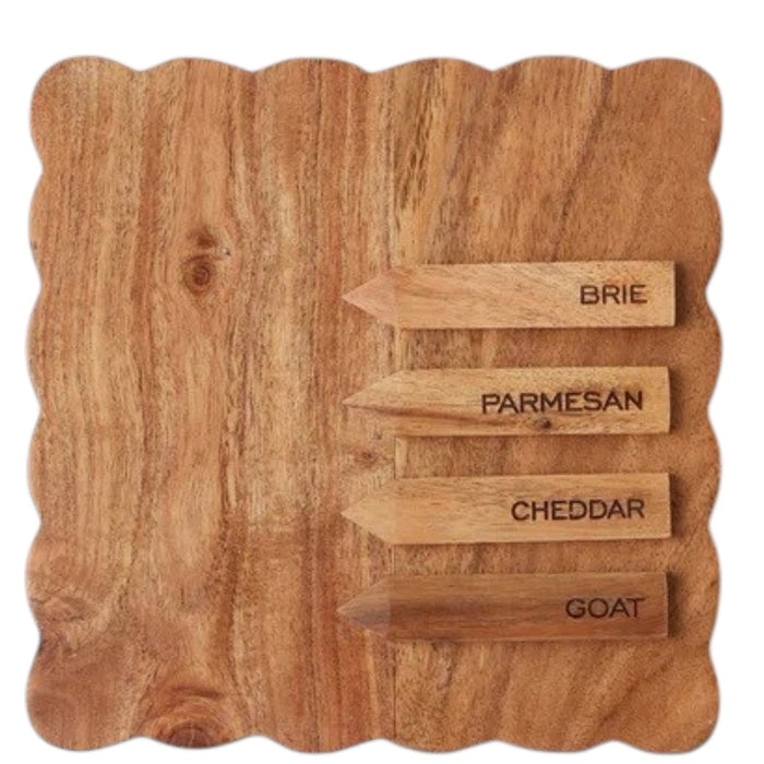 Three small savory tarts, paired with green leaves, are displayed on the ETUHOME Natural Square Scalloped Cheese Board with Markers, set against a floral-patterned background.