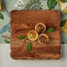 The ETUHOME Natural Square Scalloped Cheese Board includes four right-pointing, vertically arranged arrow markers labeled "BRIE," "PARMESAN," "CHEDDAR," and "GOAT" for a stylish and organized cheese presentation.