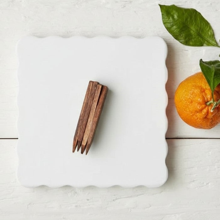 The ETUHOME White Square Scalloped Cheese Board with Markers features a chic plate and four wooden cheese markers—BRIE, PARMESAN, CHEDDAR, and GOAT—ideal for stylishly serving your favorite cheeses.