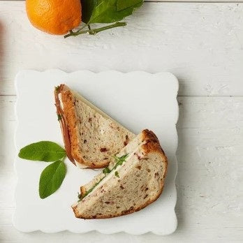 The ETUHOME White Square Scalloped Cheese Board with Markers features a chic plate and four wooden cheese markers—BRIE, PARMESAN, CHEDDAR, and GOAT—ideal for stylishly serving your favorite cheeses.