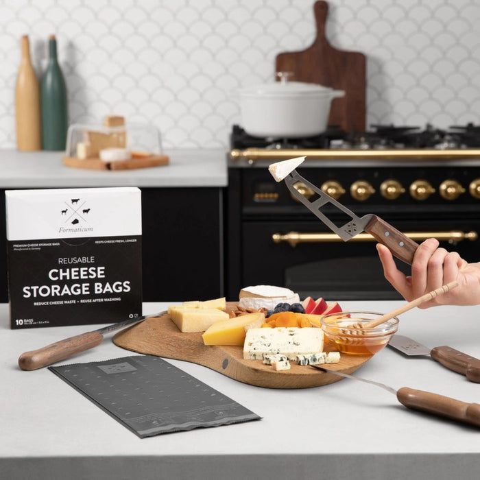A box of FORMATICUM - REUSABLE CHEESE STORAGE BAGS by FORMATICUM features a white and black design, “Reduce cheese waste” and “Keeps cheese fresher, longer” text, and contains 10 reusable bags.