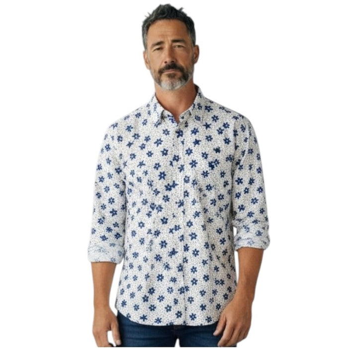 A man with short gray hair and a beard wears the FRANK & EILEEN Finbar Men's Button Up Shirt in Blue and White Small Flowers Big Flowers. He pairs it with dark jeans, standing against a plain white background for an everyday look.