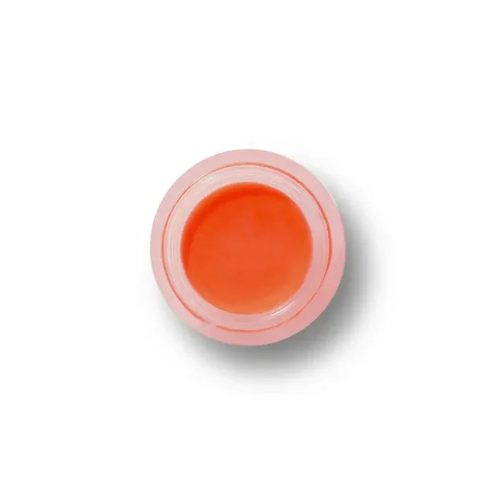 Small container of orange cream on a white background
