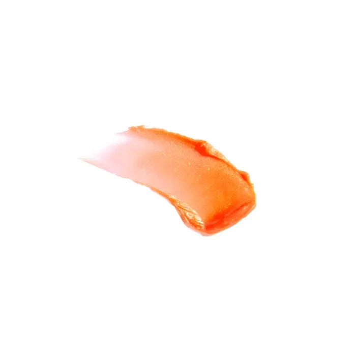 Orange lip balm smear on a white background