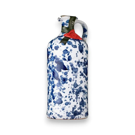 The GALANTINO - EXTRA VIRGIN OLIVE OIL by ZIA PIA IMPORTS comes in a hand-painted ceramic bottle with blue splatter patterns on white, a handle, and is topped with a green seal and red wax stamp.