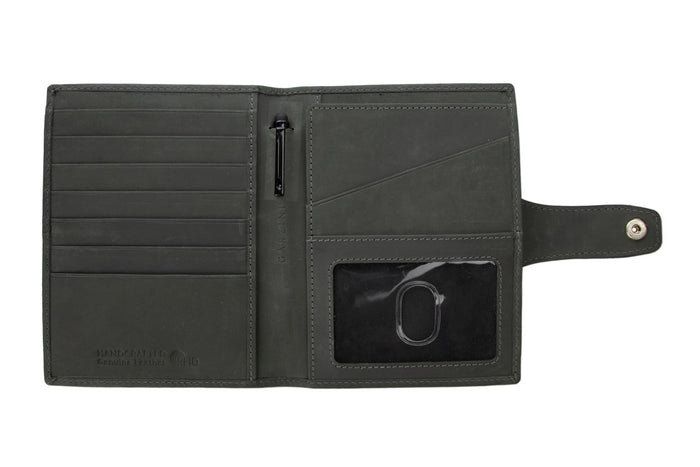 The GARZINI RFID-blocking leather passport holder in black features an AirTag compartment and snap button closure, shown on a white background.