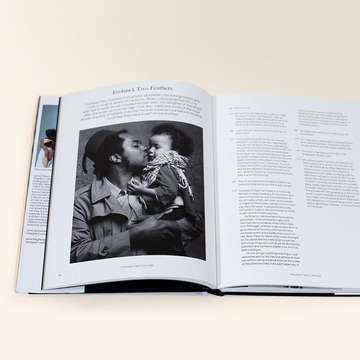 Open book displaying a black and white photograph of a man kissing a baby on one page with text on the adjacent page