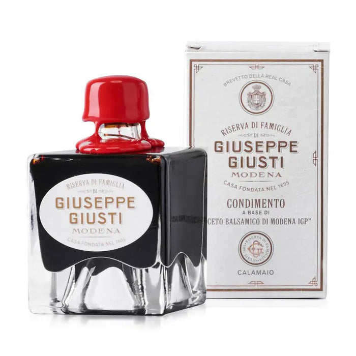 A square bottle of GIUSEPPE GIUSTI - FAMILY RESERVE BALSAMIC VINEGAR by MERCATO DI BELLINA with a red wax seal sits beside its matching white and gold box displaying the brand and product details.