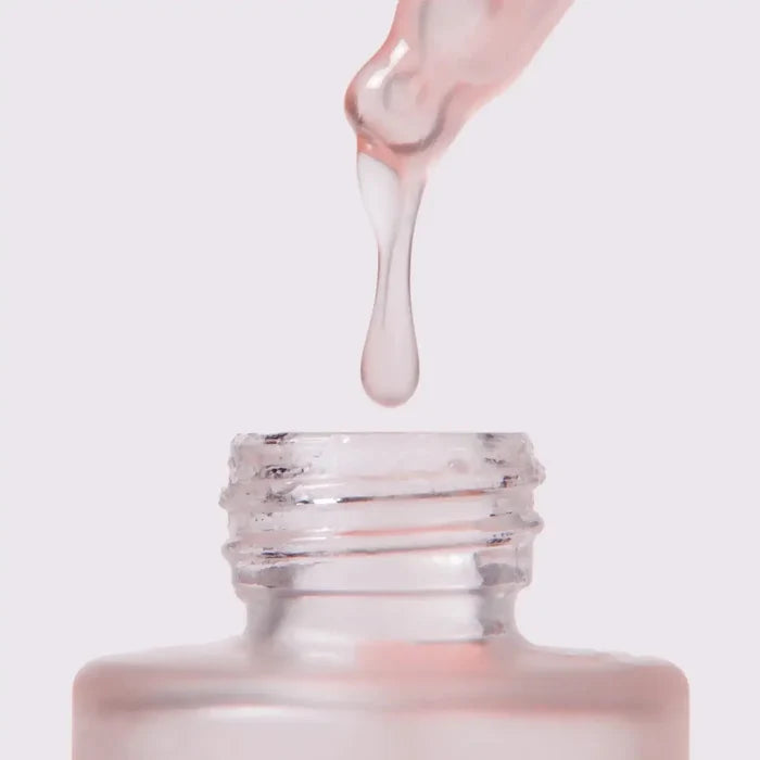 Glow Serum dropper extracting serum from the bottle, highlighting the luminous texture of the product.
