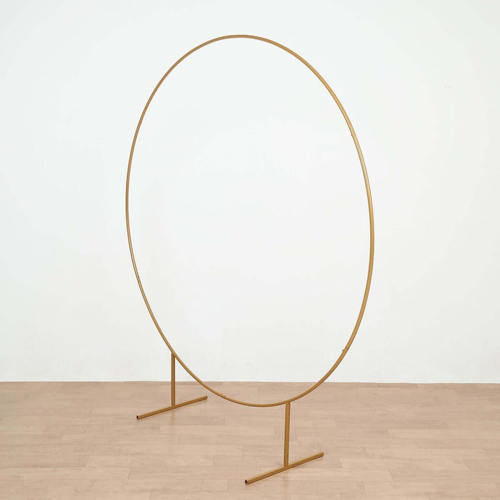 Gold circular photo backdrop stand on a plain surface.